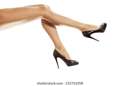 pretty female legs with black high heels on white background