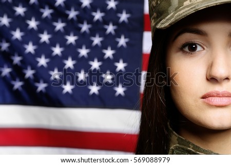 Pretty female soldier with USA flag on background, closeup
