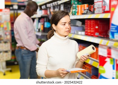 Pretty Female Standing With Office Stationery, During Shopping With Man In Stationery Shop