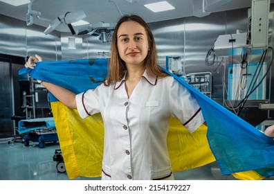 Pretty Female Surgeon Or Nurse Poses And Supports Peoples In The Ukrainian Flag During The War With Russia. Global Support For Ukraine