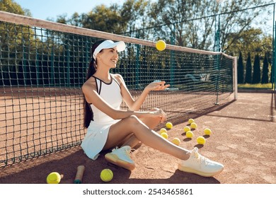 Pretty female tennis player resting after the game and looking contented - Powered by Shutterstock