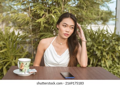 A Pretty Filipino Woman Longing For Someone. Feeling Anxious While Waiting For Her Boyfriend's Reply. Possible Ghosting Or Spat.