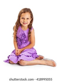 Pretty five year old girl with long blonde hair wearing purple dress sitting on white background