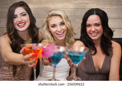 Pretty Friends Drinking Cocktails Together Against Wooden Surface With Planks