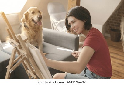 Pretty girl artist drawing sketch with golden retriever dog using pencil and canvas. Beautiful young woman painting portrait of cute doggy pet - Powered by Shutterstock