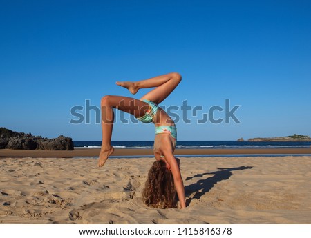 Pretty girl at the beach doing body training in yoga-pilates-gymnastics-calisthenics