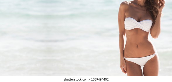 Pretty girl in bikini with perfect body at tropical sea beach