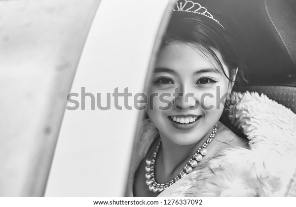 Pretty girl chinese smiling happy bride young\
asian woman smiles through car\
window