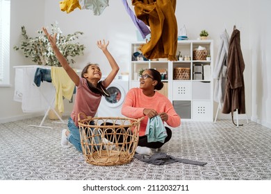 Pretty Girl Disturbs Mom Doing Laundry, Wants To Spend Time With Woman, Play, Daughter Throws Clothes Out Of Basket, Tosses Them Up, They Laugh, Joke