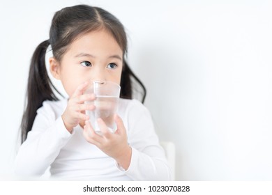 Pretty Girl Is Drinking A Glass Of Water And Looking At Outside.