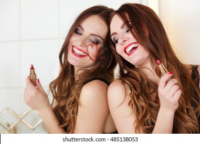 Pretty girl having fun in bathroom. Funny concept during makeup. Draw of heart
