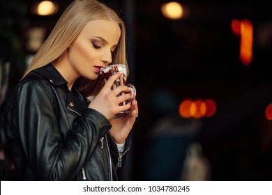 Pretty girl hold a cup of delicious coffee and waer glasses. Sun shine photo with girl drink her cappucino - Shutterstock ID 1034780245