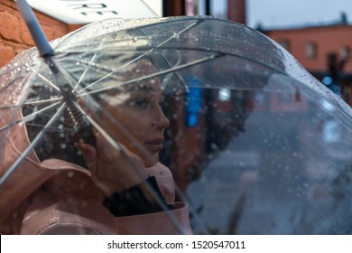 Pretty Girl Holding Umbrella And Strolling On Rainy Autumn Day. Photo Looks Like Film Frame Or Movie Screenshot. Processed In Cold Colors