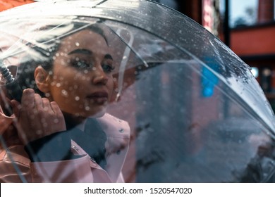 Pretty Girl Holding Umbrella And Strolling On Rainy Autumn Day. Photo Looks Like Film Frame Or Movie Screenshot. Processed In Cold Colors