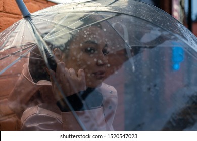 Pretty Girl Holding Umbrella And Strolling On Rainy Autumn Day. Photo Looks Like Film Frame Or Movie Screenshot. Processed In Cold Colors