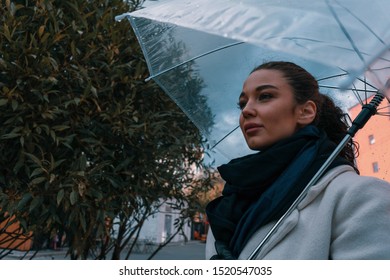 Pretty Girl Holding Umbrella And Strolling On Rainy Autumn Day. Photo Looks Like Film Frame Or Movie Screenshot. Processed In Cold Colors