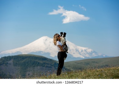 Pretty Girl Hug Black And White Dog Border Collie Stay Beiside Mountain In Field