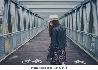 Pretty Girl With Long Hair Walking Away On A Bridge