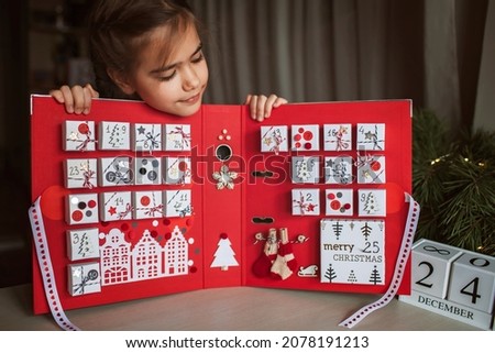 Pretty girl looks at original advent calendar made of jewelry boxes and a binder, New Year craft, diy. Magic of moment, seasonal activity, Christmas miracle. Soft focus, depth of field