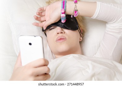 Pretty Girl Lying In Bed Pulling Up Sleeping Mask To See What Time Is It/ Wake Up, Or Cant Sleep Concept