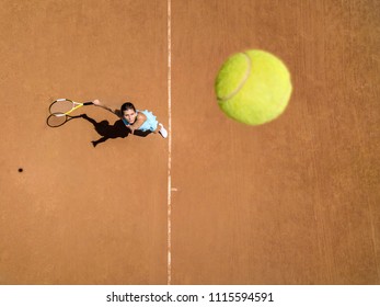 Pretty girl plays tennis on the court outdoors. She prepares to beat on a ball. Woman wears a light blue sportswear with white sneakers. Top view horizontal photo. - Shutterstock ID 1115594591