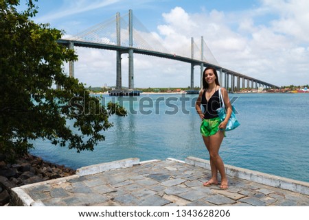 The pretty girl posing for photos in Natal with Potengi river and Newton Navarro bridge in background/