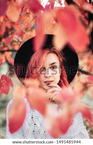 Young redhead woman surrounded by plants