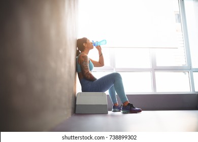 Pretty Girl Rest And Drink Water In Gym.