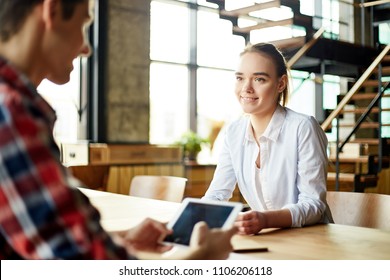 Pretty girl sitting with man and doing homework using tablet and talking helping each other - Shutterstock ID 1106206118
