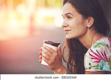 pretty girl sitting in street with morning coffee