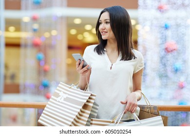 Pretty Girl With Smartphone Shopping In The Mall