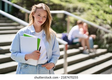 Pretty girl university student holding notebooks looking at camera posing for outdoor portrait. College study programs, academic educational courses ads, learning classes concept. - Shutterstock ID 2187470255