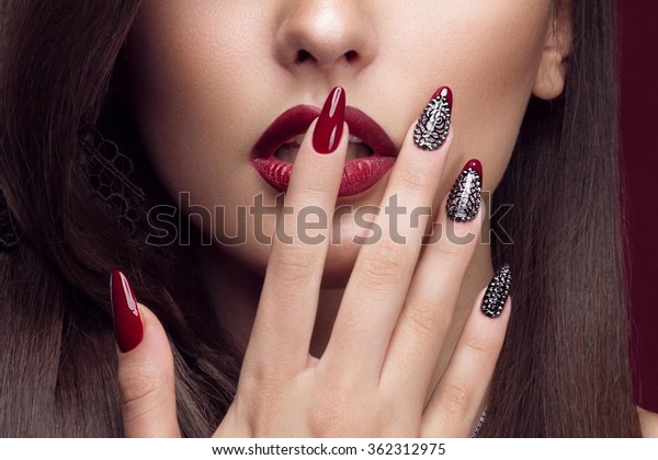 Pretty\
girl with unusual hairstyle, bright makeup, red lips and manicure\
design. Beauty face. Art nails. Studio\
portrait