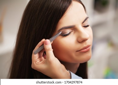 Pretty girl uses the services of a professional makeup artist in a beauty studio