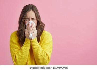 Pretty Girl Or Young Woman Is Sneezing Into A Tissue Because Of Her Allergy Or Cold. Concept: Sneeze