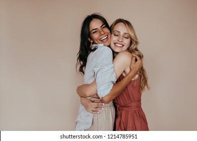 Pretty girls with trendy makeup embracing on light background. Excited caucasian sisters expressing love. - Shutterstock ID 1214785951