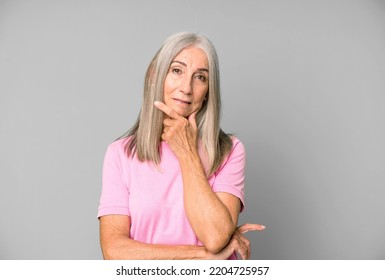 Pretty Gray Hair Senior Woman Looking Serious, Thoughtful And Distrustful, With One Arm Crossed And Hand On Chin, Weighting Options