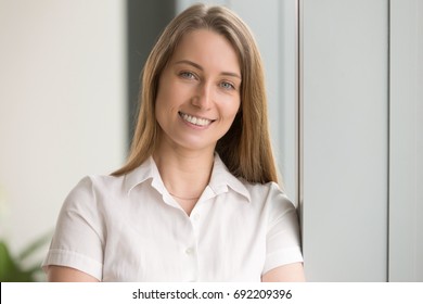 Pretty happy businesswoman looking at camera, head shot portrait of friendly attractive life coach posing with wide toothy smile, successful company manager feeling motivated, loves her job