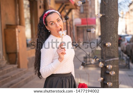 pretty happy caucasian woman walking in the city with lollipop