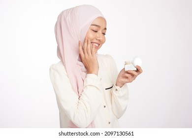 Pretty Hijab Girl Apply New Skin Care CBD, HEMP Cream Jar On Her Face To Make Face Soft Fresh Nature Isolated 