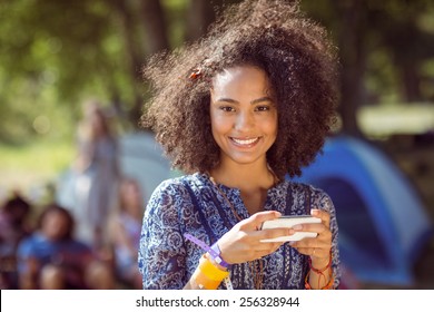 Pretty hipster sending text message at a music festival - Powered by Shutterstock