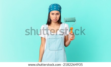 pretty hispanic woman feeling sad and whiney with an unhappy look and crying. painting home concept