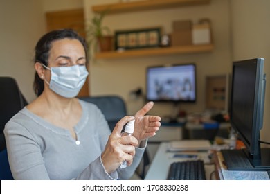 Pretty Hispanic Woman In Mask Cleans Her Hands At Home, Defending Against Coronavirus