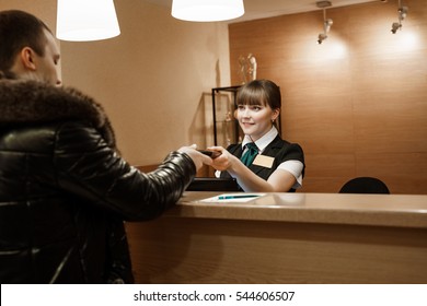 Pretty Hotel Receptionist Giving Key To Male Guest