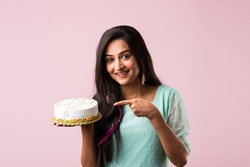 Pretty Indian Asian Young Woman Or Girl Holding Birthday Cake Against Pink Background