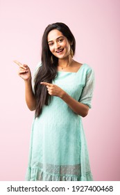 Pretty Indian asian young woman or girl presenting against pink background