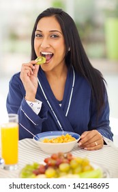 Pretty Indian Woman Eating Kiwifruit During Breakfast