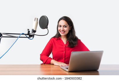 Pretty Indian woman speaks in front of microphone while recording a video blog for his subscribers, looking at camera - Shutterstock ID 1840503382