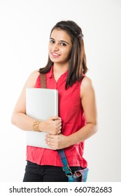 Pretty Indian/Asian young college Girl holding Laptop Computer, Standing isolated against white background