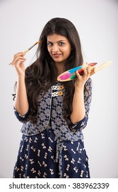 Pretty Indian/asian Young Girl Artist With Paint Brush And Colour Palate, Standing Isolated Over White Background